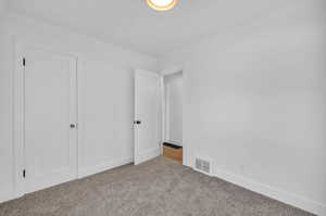 Unfurnished bedroom with crown molding and light carpet