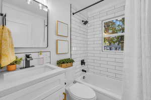 Full bathroom featuring shower / tub combo, vanity, and toilet