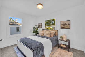 Bedroom with ornamental molding and carpet flooring