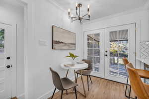 Dining area featuring ornamental molding, french doors, and light hardwood / wood-style flooring