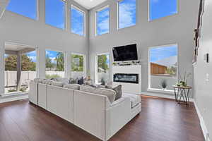 Living room featuring a towering ceiling and dark wood-type flooring