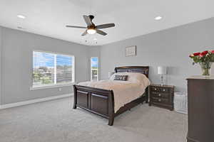 Carpeted bedroom with ceiling fan and a textured ceiling