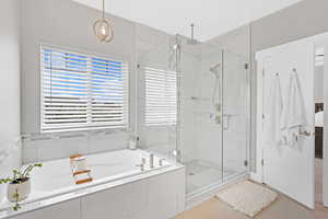 Bathroom featuring tile patterned flooring and shower with separate bathtub