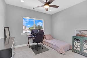 Carpeted bedroom featuring ceiling fan