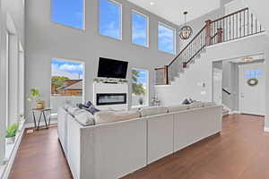 Living room featuring an inviting chandelier, a towering ceiling, and dark hardwood / wood-style floors