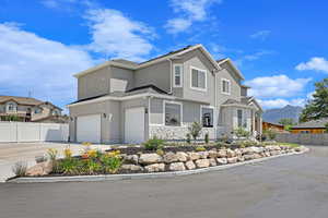 View of front of property with a garage and a mountain view