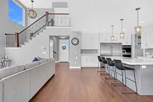 Living room with dark hardwood / wood-style floors, a chandelier, and a high ceiling