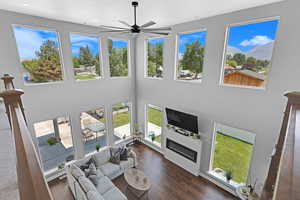 Living room featuring ceiling fan, a wealth of natural light, and dark hardwood / wood-style flooring