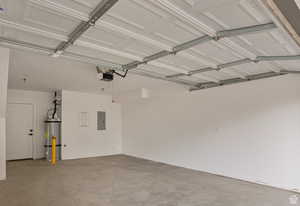 Garage with electric panel, water heater, and a garage door opener