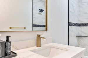 Bathroom with tiled shower and vanity