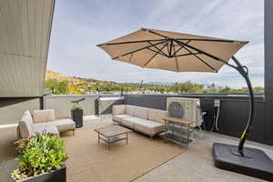 View of patio with a balcony, an outdoor hangout area, and ac unit