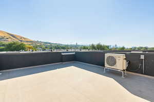 View of patio with a mountain view and ac unit