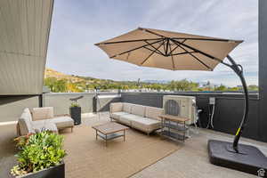 View of patio / terrace with a balcony, an outdoor hangout area, and ac unit