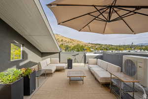 View of patio / terrace with ac unit, a mountain view, and an outdoor living space