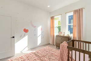 Bedroom with light carpet and a nursery area