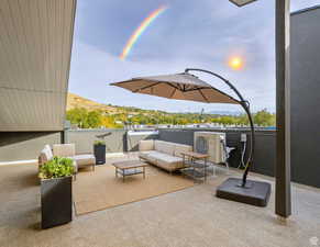 Patio terrace at dusk with a balcony, a mountain view, and an outdoor living space