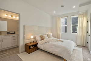 Bedroom featuring sink and light carpet