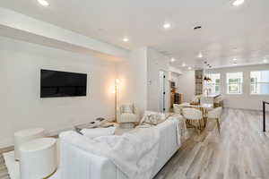 Living room with sink and light hardwood / wood-style floors