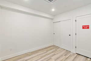 Unfurnished bedroom featuring a closet and light hardwood / wood-style floors