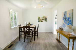 Dining space with dark hardwood / wood-style floors and a notable chandelier