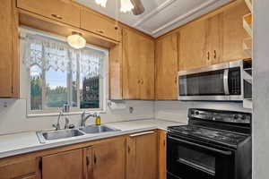 Kitchen with ceiling fan, black electric range oven, sink, and plenty of natural light