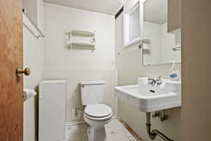 Bathroom featuring tile patterned flooring, sink, and toilet