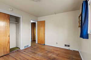 Unfurnished bedroom featuring a closet and wood-type flooring