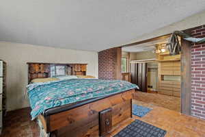 Bedroom with a closet, parquet flooring, a textured ceiling, and ceiling fan