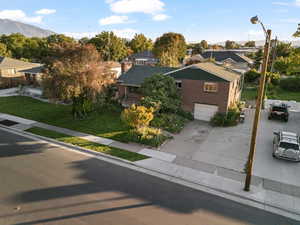 View of front of home with a mountain view, a front yard, and a garage