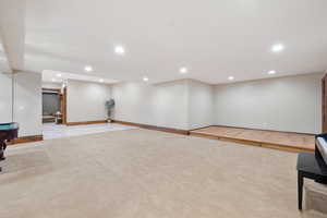 Basement with light colored carpet and billiards