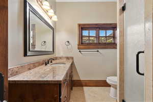 Bathroom featuring vanity, tile patterned flooring, and toilet