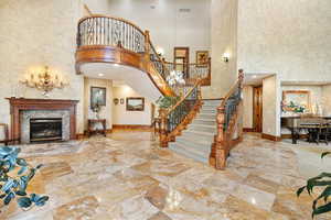 Entryway featuring a high ceiling and a fireplace