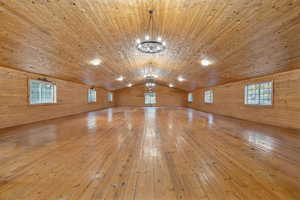 BARN UPPER-LEVEL Bonus room with wood-type flooring, wooden walls, lofted ceiling, and wooden ceiling