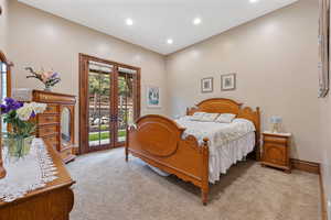 Carpeted bedroom featuring access to outside and french doors