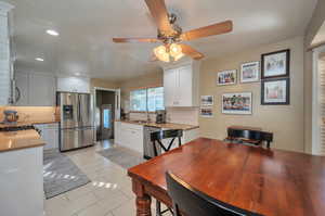 Kitchen with tasteful backsplash, sink, stainless steel appliances, and white cabinets