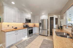 Kitchen featuring white cabinets, appliances with stainless steel finishes, sink, and quartz counters