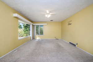 Living room with carpeted floors and lots of natural light