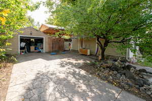 View of patio featuring a garage and an outbuilding