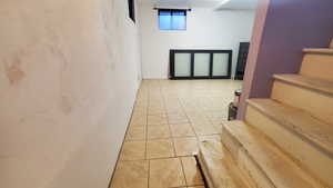 Basement with light tile patterned flooring