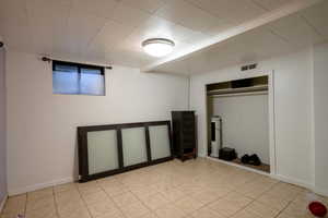 Unfurnished bedroom featuring light tile patterned flooring and a closet