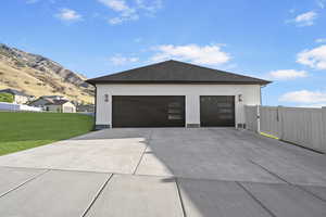 Garage with a mountain view and a yard