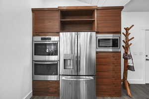 Kitchen featuring stainless steel appliances and dark hardwood / wood-style flooring