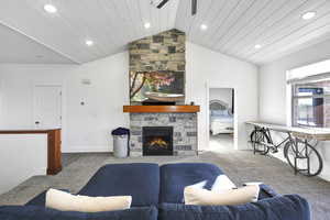 Living room with lofted ceiling, a fireplace, and light colored carpet