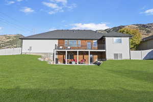 Back of house featuring a yard, a patio area, and a mountain view