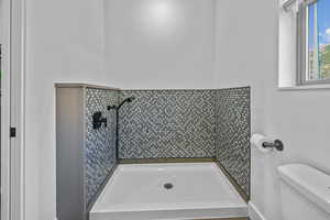 Bathroom with a tile shower and toilet