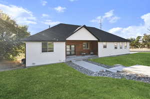 Back of property with a patio and a lawn