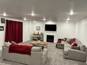 Carpeted living room featuring a textured ceiling