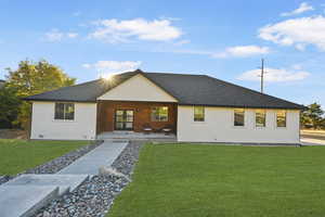 View of front facade featuring a front lawn and a patio