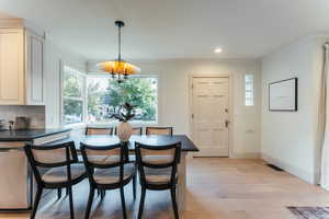 Dining space featuring a notable chandelier, crown molding, and light hardwood / wood-style floors