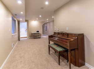 Living area with carpet floors, baseboards, recessed lighting, and visible vents